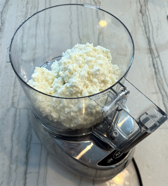 Pour a 24 oz. container (3 cups) of fat free cottage cheese into a food processor. 