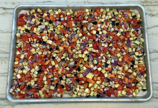 Line a 15 x 10 x 1 baking sheet with parchment paper. Then spread the vegetables evenly out over the parchment paper.