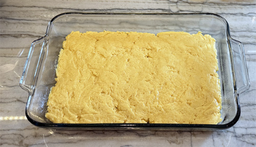 Press into the bottom of the 13x9 pan. I use a spatula that I coat with the buttery cooking spray so it doesn't stick to the dough. That allows me to spread it evenly.