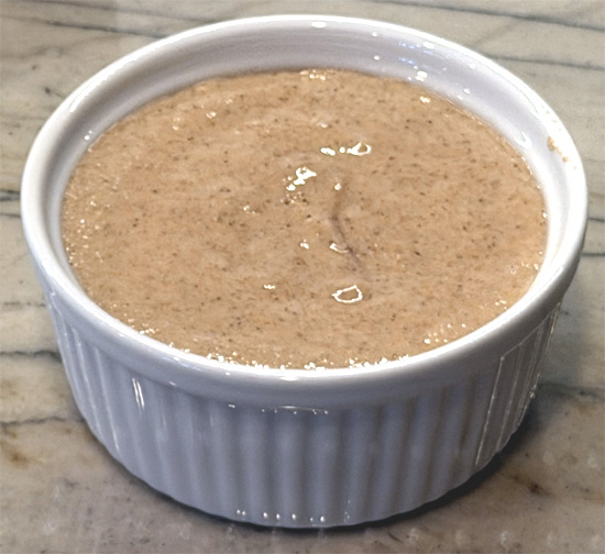 Using a fork, mix in fat-free milk, vanilla extract, and sugar-free maple syrup until just combined. Pour batter into the prepared ramekin.