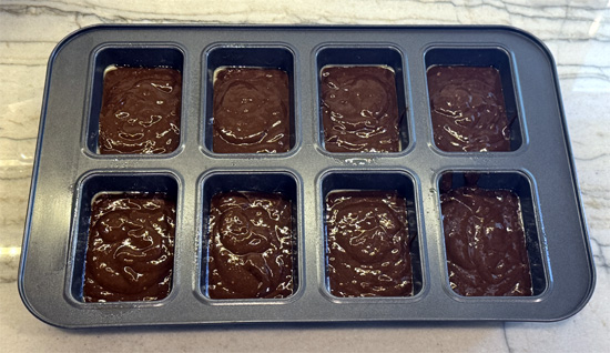 Evenly fill each of the eight trays with about half a cup of batter. 