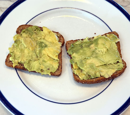Split the avocado between the two slices, spreading it evenly on each piece. 