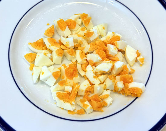 Hard boil the eggs: Place 2 large eggs in a pot with 4 cups of cold water. Bring to a boil over high heat, then remove from heat and cover. Let sit for 12–14 minutes, then transfer eggs to an ice bath for 10 minutes. Peel, chop, and set aside. 