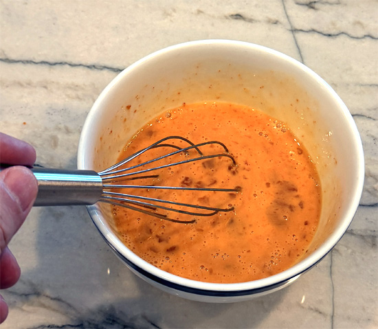 In a small bowl, whisk together the whole egg, egg whites, heavy cream, and gochujang until smooth.
