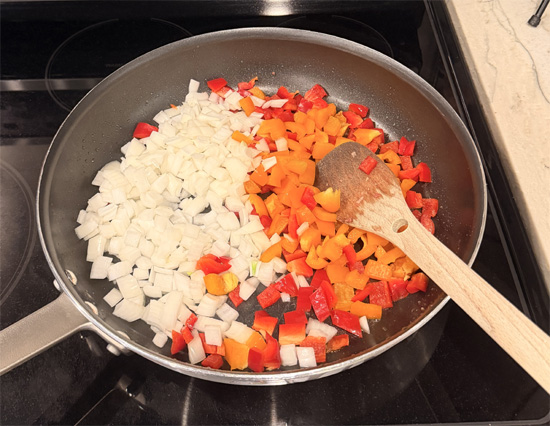 In the same skillet, sauté peppers and onions until peppers soften and onions start to brown. Add to the meat and bread mixture. 