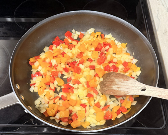 In the same skillet, sauté peppers and onions until peppers soften and onions start to brown. Add to the meat and bread mixture. 