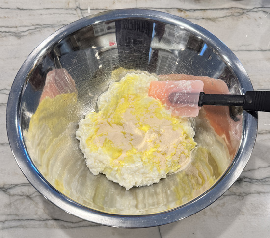 In a large mixing bowl, combine cottage cheese and lemon Jell-O powder until well blended.