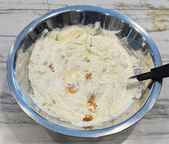 Add drained mandarin oranges and fold in carefully to avoid breaking the segments.