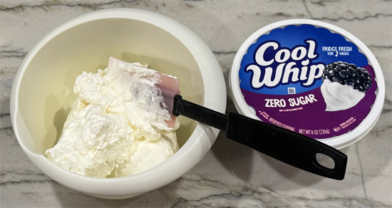 Make filling: While chocolate hardens, mix the peanut powder and protein powder into the Cool Whip until fully incorporated.