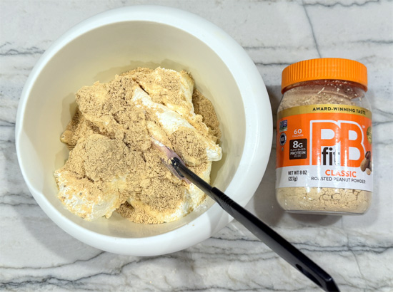 Make filling: While chocolate hardens, mix the peanut powder and protein powder into the Cool Whip until fully incorporated.