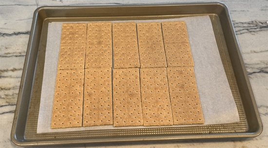 Find a pan that will hold 10 graham cracker halves and fit in your freezer. Line with parchment paper and arrange the cracker halves on the paper.