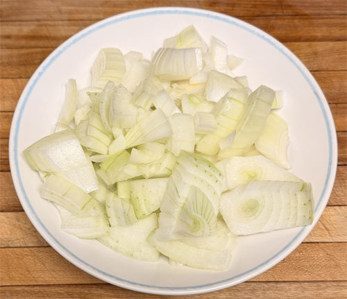 Spread chopped onions and bell peppers over chicken.