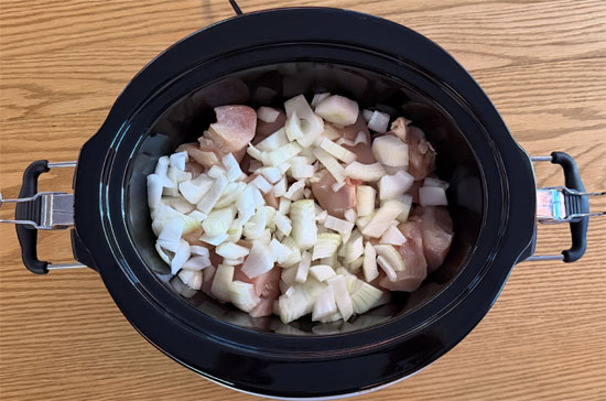 Spread chopped onions and bell peppers over chicken.