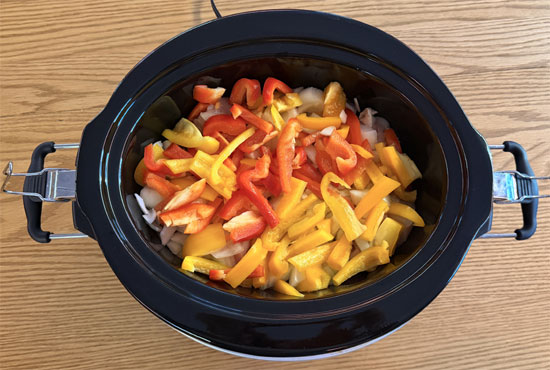 Spread chopped onions and bell peppers over chicken.