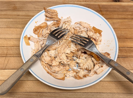 While quinoa is cooking, remove chicken from slow cooker and shred with two forks. Return shredded chicken to pot and stir into sauce.