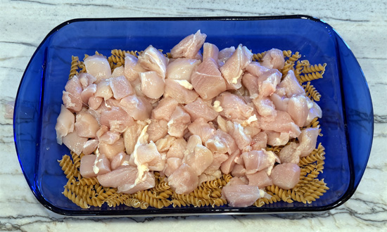 Mix together the pasta, chicken, bell peppers, onion, garlic, cream cheese, tomatoes, water, fajita seasoning. 