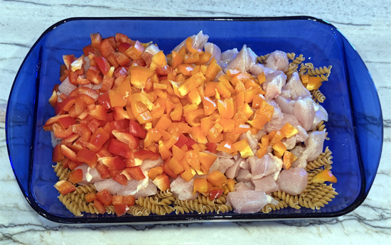 Mix together the pasta, chicken, bell peppers, onion, garlic, cream cheese, tomatoes, water, fajita seasoning. 