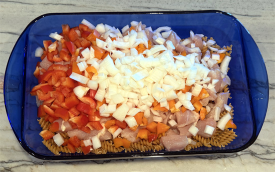 Mix together the pasta, chicken, bell peppers, onion, garlic, cream cheese, tomatoes, water, fajita seasoning. 