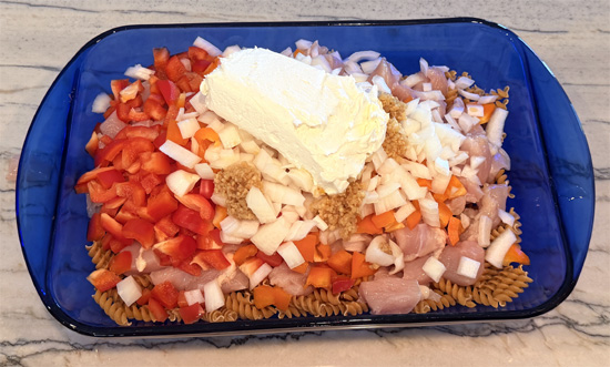 Mix together the pasta, chicken, bell peppers, onion, garlic, cream cheese, tomatoes, water, fajita seasoning. 