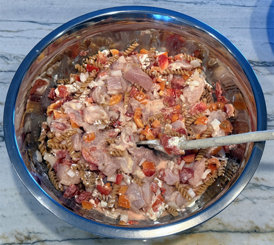 Mix together the pasta, chicken, bell peppers, onion, garlic, cream cheese, tomatoes, water, fajita seasoning. 