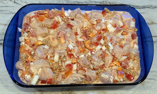 Mix together the pasta, chicken, bell peppers, onion, garlic, cream cheese, tomatoes, water, fajita seasoning. 