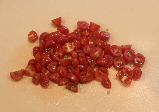 Cut the grape or cherry tomatoes in half, and cut any larger tomatoes into thirds; set them aside.
