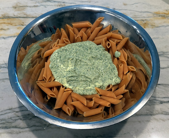 Drain the pasta, immediately transfer it to a large mixing bowl, add the spinach–cottage cheese sauce, the chopped tomatoes, the cooked chicken, and 1 cup of the shredded Parmesan cheese, then stir until everything is well combined and the cheese has melted over the pasta.