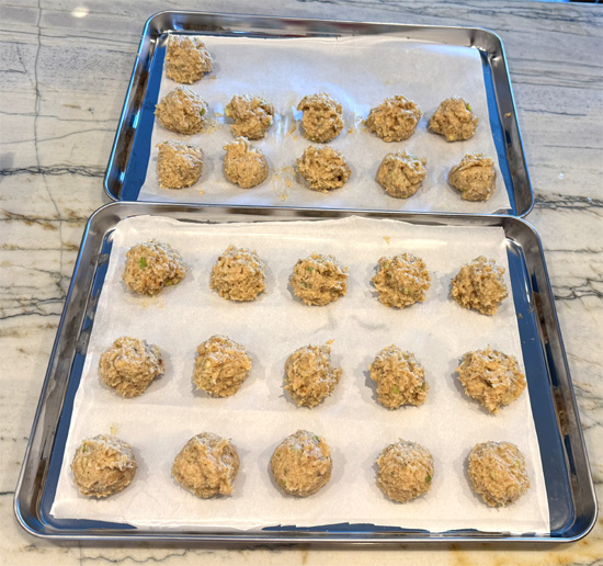 Shape and Bake the Meatballs: Form the mixture into 26 meatballs, about 2 inches wide each. Place them on the baking sheets and bake in the preheated oven for 20 minutes or until the internal temperature reaches 165°F.