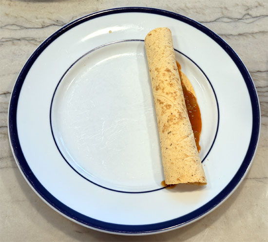 Lay out the tortillas and spread 2 Tbsp. of the enchilada mixture on each one. Wrap each tortilla around a hot dog and place it seam side down in the baking dish, on top of the beans.