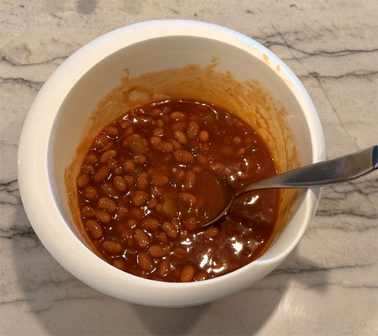Mix the remaining baked beans with the remaining enchilada mixture and spread it over the rolled hot dogs.