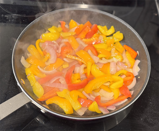 Start the sauce: While quinoa cooks, heat a large skillet over medium heat. Add 3 Tbsp olive oil, onions, and bell peppers. Cook gently until softened, stirring occasionally, 5-10 minutes.