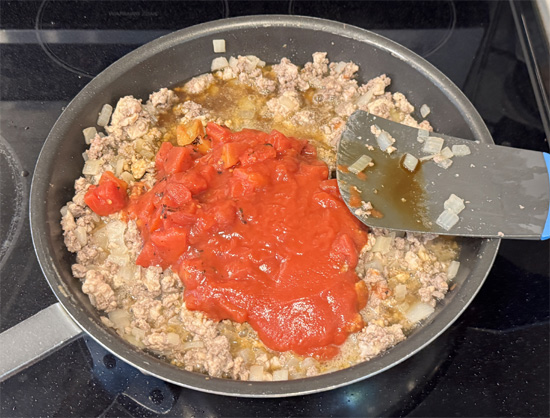 Add the fire-roasted tomatoes, tomato sauce, pinto beans, salt, and black pepper to the pan. Stir it all together. Let the mixture simmer for about 5-6 minutes, allowing the flavors to combine.