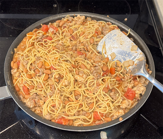 Add the drained cooked spaghetti directly to the skillet and combine, making sure the noodles are well coated in the sauce. You may have to cut the noodles up a little for them all to combine well. Reduce heat to low and let simmer for about 5 minutes.
