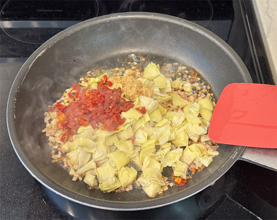 Stir in artichoke hearts, sun-dried tomatoes, and garlic. Cook 1 minute.