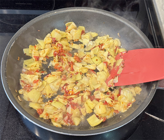 Stir in artichoke hearts, sun-dried tomatoes, and garlic. Cook 1 minute.
