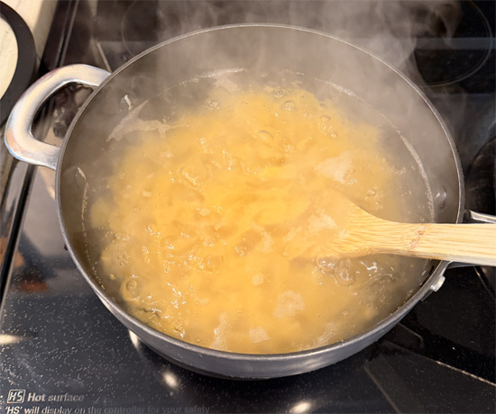 Cook the pasta according to package directions. Drain and return to the pot. Set aside.