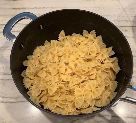 Cook the pasta according to package directions. Drain and return to the pot. Set aside.