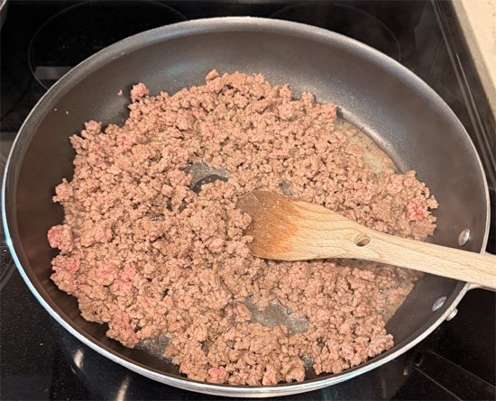 Heat a large skillet (at least 14 inches across) over medium-high heat. Add ground beef and cook just until no longer pink, breaking it up while cooking. 