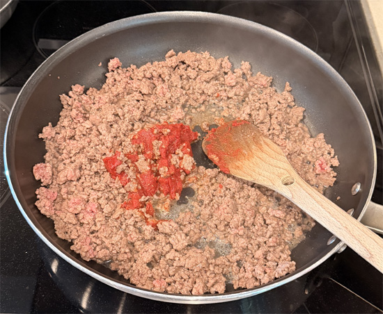 As soon as the beef is no longer pink (but not yet browned), stir in the tomato paste. Add the halved tomatoes and cook until the tomatoes start to fall apart and beef browns, about 5 more minutes. 