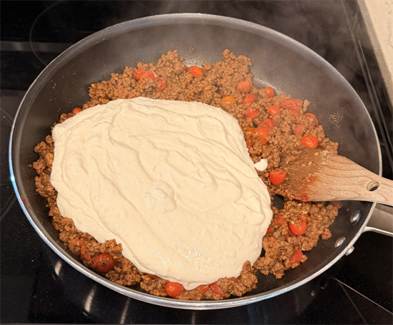 Reduce heat to low and pour in the cheese sauce. Mix well and let simmer for 2-3 minutes. 