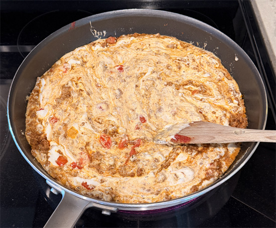 Reduce heat to low and pour in the cheese sauce. Mix well and let simmer for 2-3 minutes. 