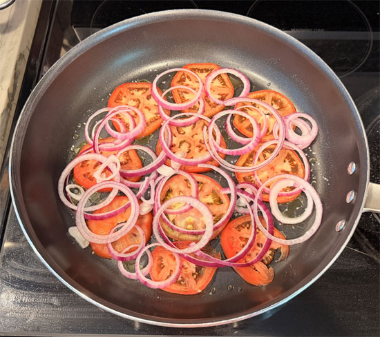 Sprinkle the salt over the oil, then layer the tomato slices and onion across the bottom of the pan. 
