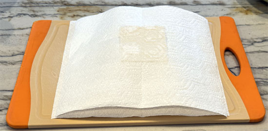 Drain the tofu, wrap it in a clean towel, set it on a plate and put a cast iron skillet or other heavy object on top. Let it press for at least 10 minutes, up to an hour.