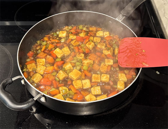Put the tofu back in the pan with the vegetables and pour the sauce over everything. Stir to coat and keep stirring until the sauce simmers and thickens, about 2 minutes.