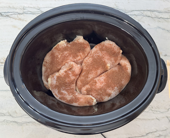 Sprinkle half the seasoning over the chicken, flip the breasts, then sprinkle the remaining seasoning on the other side.