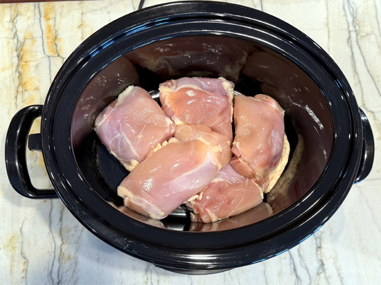 Place chicken thighs in the bottom of the slow cooker.
