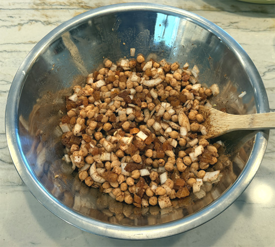 Add Baharat spice (and cayenne pepper, if using) to the chickpea mixture and stir well.
