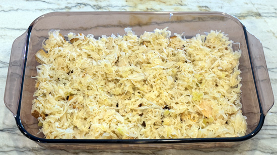 Layer the drained sauerkraut over the bread, then spread the chopped pastrami, followed by the sour cream mixture, then the mozzarella and finally the Swiss cheese over top.