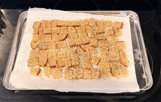 Cut the bread into small 1 inch squares. Spread the bread squares on the prepared baking sheet. Spray with olive oil and sprinkle with 1 Tbsp Everything Bagel seasoning. Bake 8 minutes, flip, spray again, and bake another 8 minutes until crunchy. Set croutons aside.