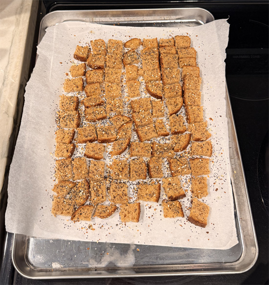 Cut the bread into small 1 inch squares. Spread the bread squares on the prepared baking sheet. Spray with olive oil and sprinkle with 1 Tbsp Everything Bagel seasoning. Bake 8 minutes, flip, spray again, and bake another 8 minutes until crunchy. Set croutons aside.